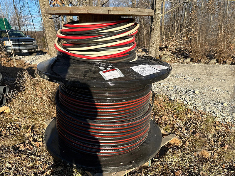 Large spool of underground service cable staged on rural property